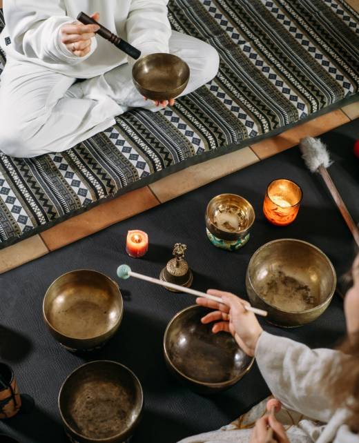 Singing bowls top view, sound healing alternative therapy. Woman playing on percussion metal music instruments. Mental health care with meditation, relaxation yoga massage